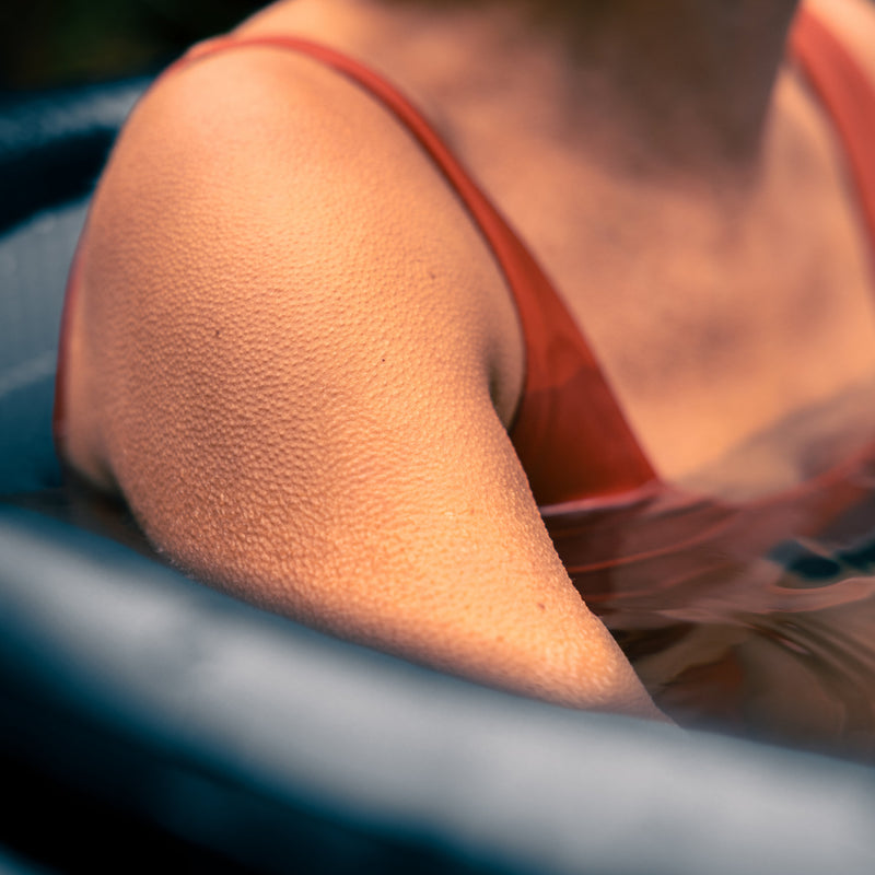 Closeup photo of a womans shoulder covered with goosebumps, whilst sat in a LUMI ice bath.