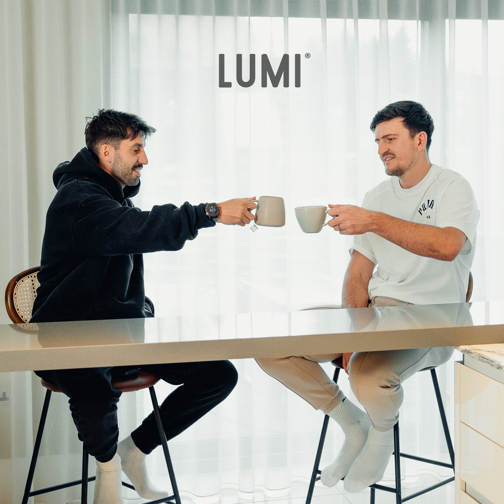 Harry Maguire and Gavin Teague, founder of Lumi Therapy, raising teacups in a celebratory toast.