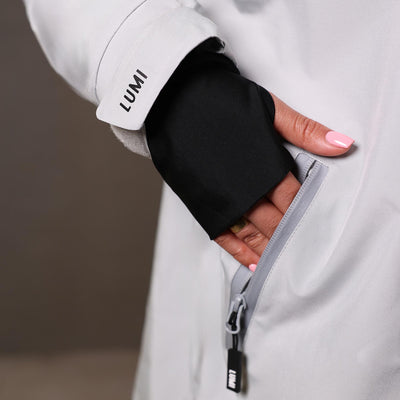 PRO DUO Changing Robe in Grey showcasing detailed sleeve design with LUMI branding, black inner cuff, and convenient side pocket with waterproof zipper, demonstrating practical functionality and premium quality construction