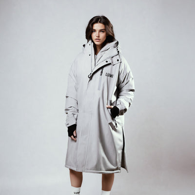PRO DUO Changing Robe in Grey - Premium waterproof outdoor robe with hooded design, featuring LUMI branding, zippered front closure, and adjustable cuffs against light grey background. Showcasing the robe's full-length cut and practical outdoor-ready design elements.