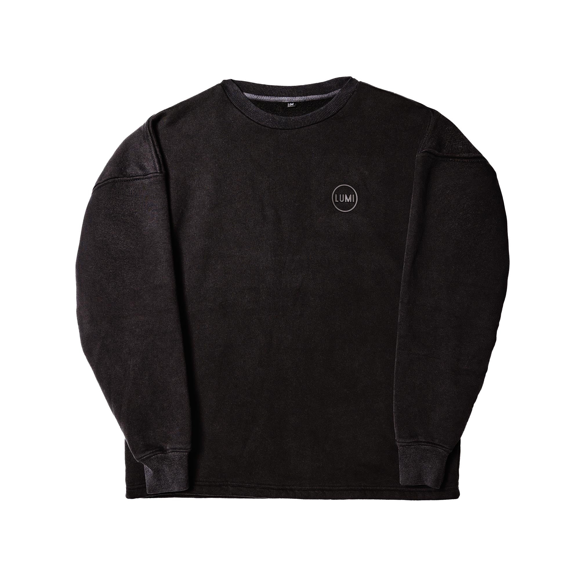 Unisex LUX Oversized Sweatshirt Black Wash featuring a relaxed fit design with drop shoulders and ribbed cuffs. The black washed cotton blend fabric showcases a subtle worn-in look, complemented by a minimalist rubber LUMI logo on the chest. Casual yet sophisticated streetwear essential.