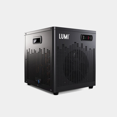 LUMI Cube Chiller portable cooling unit in matte black finish with digital display, ventilation grid pattern, and built-in handle, designed for ice bath and cold therapy applications. The compact device features camlock fittings and weather-resistant construction for efficient water cooling to 2°C.