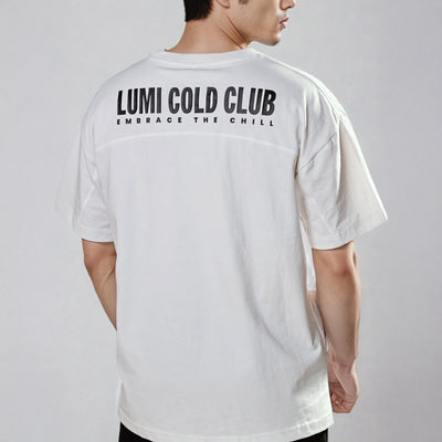 Back view of Men's LCC Oversized T-Shirt White showing LUMI Cold Club text graphic print, demonstrating oversized fit and relaxed shoulders on model against grey background