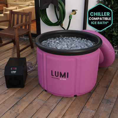 The Pink LUMI Max Ultra ice bath, filled with ice in a garden setting.