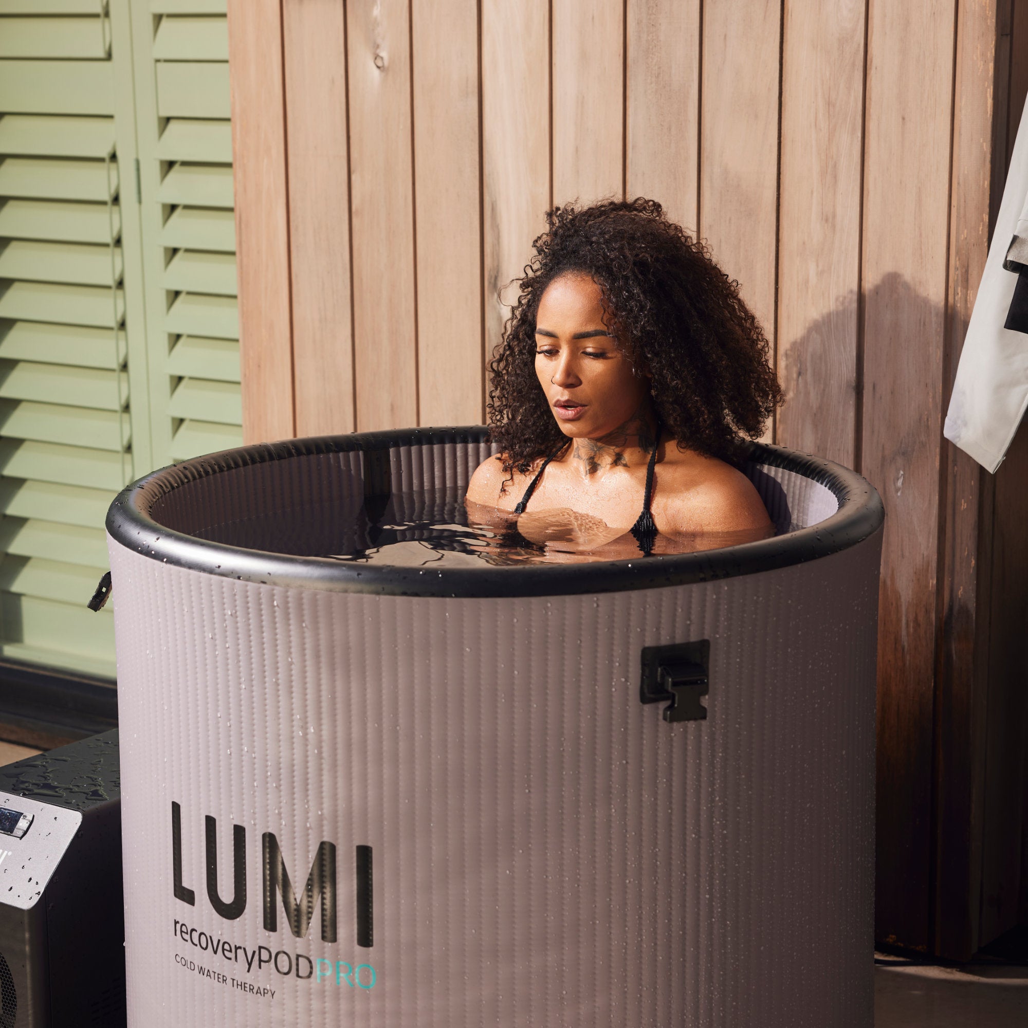 A woman using a LUMI Pod PRO ice bath for cold water therapy
