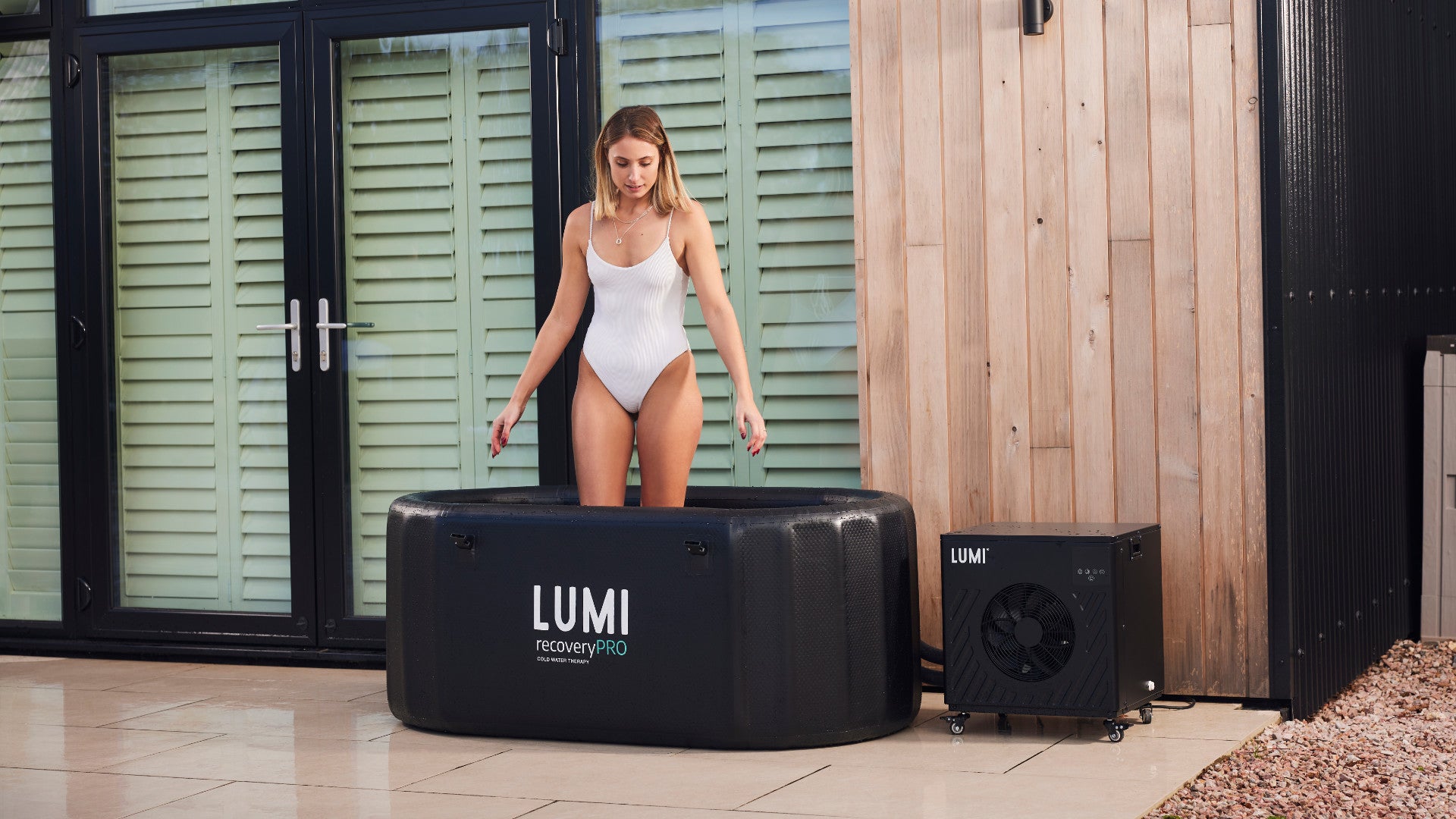 A woman stepping into a LUMI ice bath