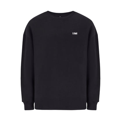 Unisex LCC Oversized Sweatshirt Black featuring a minimalist design with small white LUMI logo on chest. Classic black heavyweight cotton-polyester blend sweatshirt with ribbed cuffs and hem, shown flat against white background. Perfect for post-ice bath comfort and everyday wear.