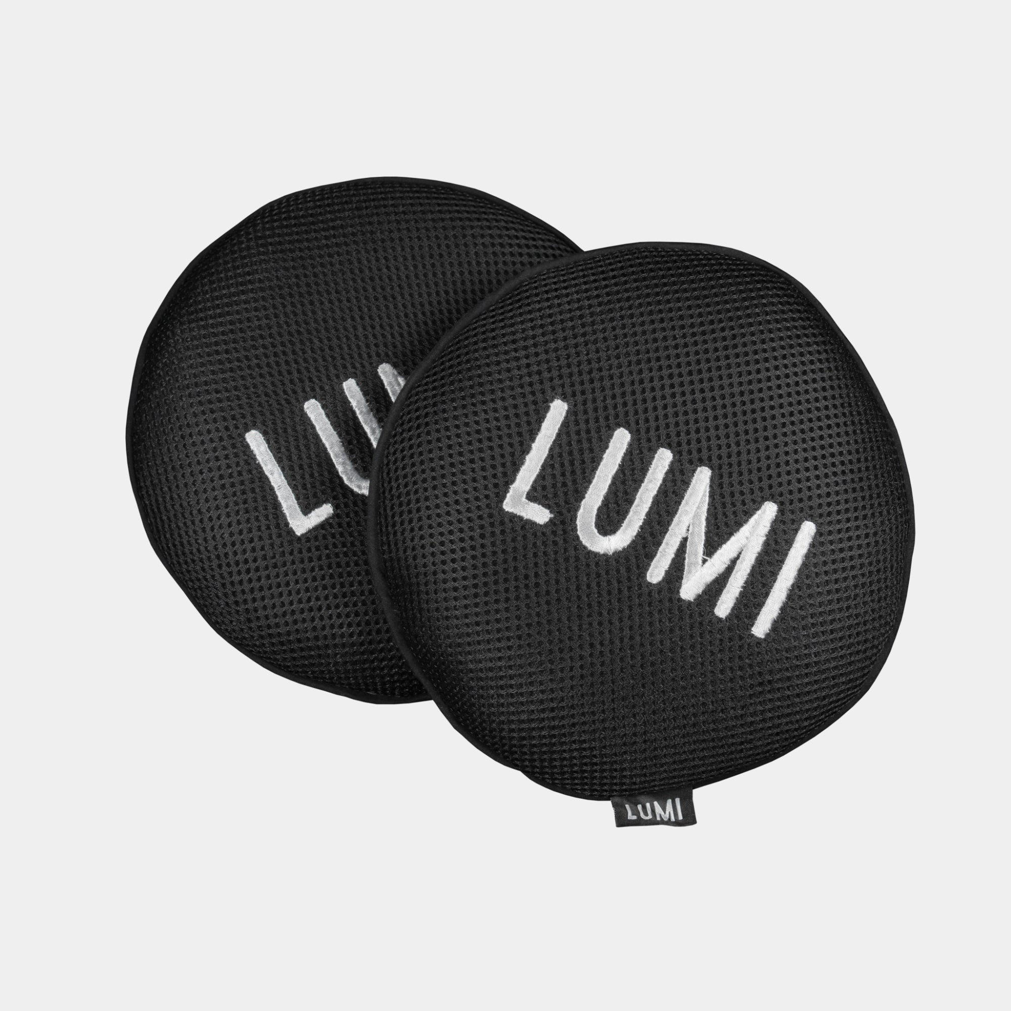 Two circular black LUMI Scum Sponges with textured mesh surface displaying white LUMI branding, designed for absorbing oils and impurities from ice baths, shown against a light background