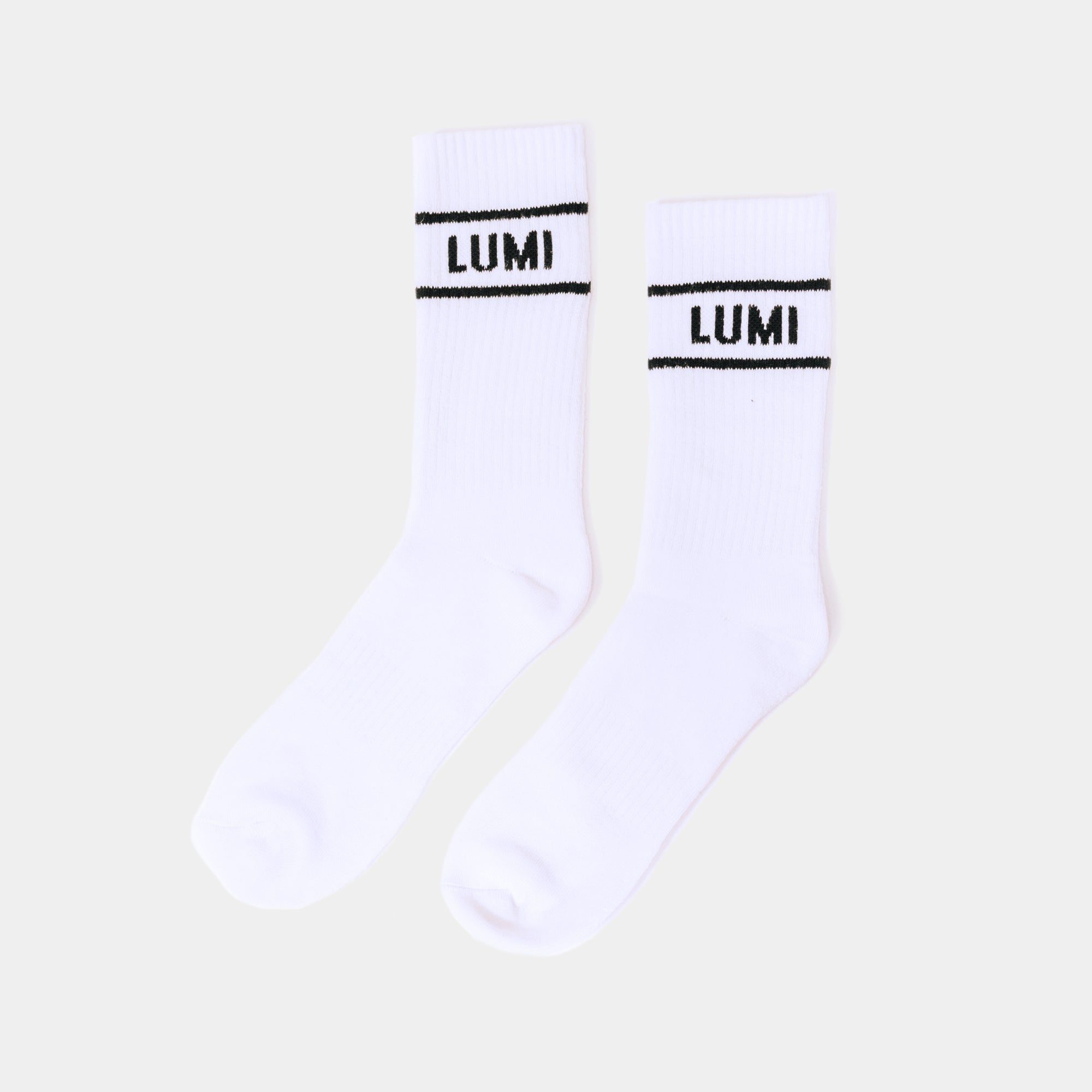 Pro Bamboo Socks with Stripes - White athletic bamboo socks featuring black LUMI logo and dual stripe design, photographed as a pair against light background, showcasing elasticated cuffs and sporty crew length style