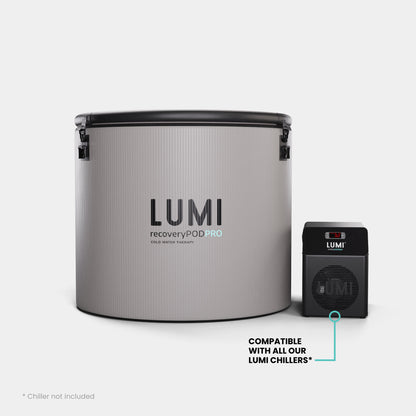 LUMI Pod PRO Ice Barrel in stone grey with black accents shown alongside compatible mini chiller unit. Features ribbed exterior design with secure latches and branded LUMI Recovery Pod PRO text. Professional-grade cold therapy equipment displayed against white background.