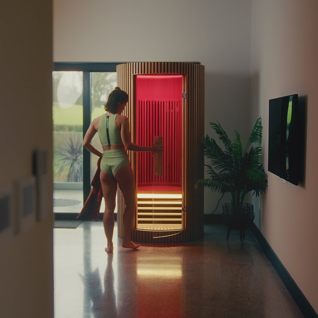 Load video: Video of a woman stepping into the LUMI Sauna PRO infrared wooden sauna.