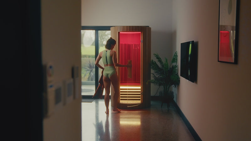 Video of a woman stepping into the LUMI Sauna PRO infrared wooden sauna.